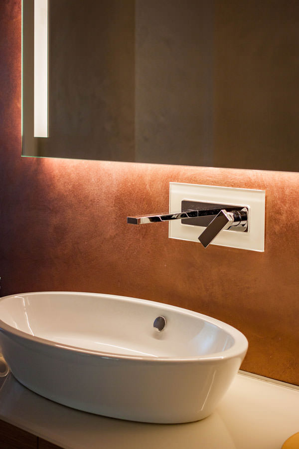 dettaglio lavabo appoggio rubinettera inox a parete specchio con illuminazione