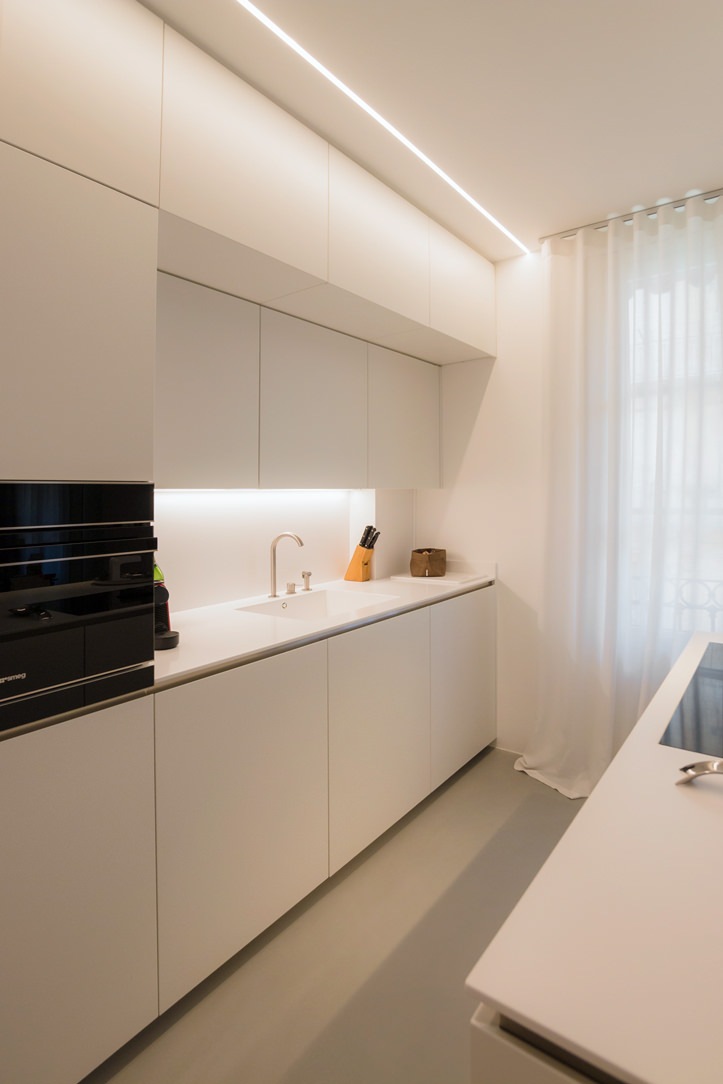 white kitchen with island wall units integrated lighting